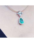 18K white gold enhancer necklace with a pear-shaped emerald and halo diamonds on a thin choker.