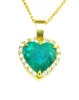 Heart-shaped emerald pendant with gold frame with diamonds and chain on toside view position.