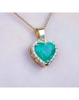 5.04 ct. emerald heart pendant with diamond halo in 18K yellow gold on a gold chain.