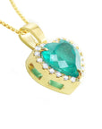 A 18k yellow gold pendant with a natural colombian emerald on a lateral side profile view.