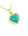 Gold necklace with a heart-shaped emerald pendant with a halo diamond on a topside view position.