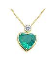 Heart-shaped emerald pendant with gold frame and diamond on a topside view.