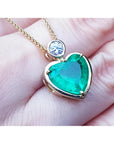 5.46 ct. heart-shaped emerald pendant in 18K yellow gold with a slider bail and bezel-set diamond.