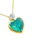 Heart-shaped emerald pendant with gold frame and diamond on a white background