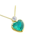 Heart-shaped emerald pendant with gold frame and diamond on a white background