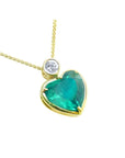 Heart-shaped emerald pendant with gold frame and diamond on a white background