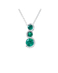 14K white gold emerald journey pendant necklace with three round, deep green emeralds encircled by diamonds.