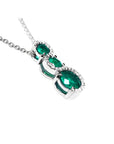 14K white gold emerald journey pendant with three round-cut Colombian emeralds and diamond accents.