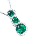 Three round cut natural colombian emeralds pendant journey necklace on a topside view position.