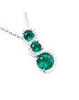 Three round cut natural colombian emeralds pendant journey necklace on a topside view position.