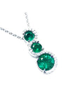 Three round cut natural colombian emeralds pendant journey necklace on a topside view position.