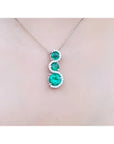 1.99 ct. emerald journey pendant necklace with three round Colombian emeralds and diamonds on a 14K gold chain.
