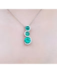 1.99 ct. emerald journey pendant necklace with three round Colombian emeralds and diamonds on a 14K gold chain.