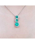 1.99 ct. emerald journey pendant necklace with three round Colombian emeralds and diamonds on a 14K gold chain.