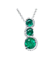 Three round cut natural colombian emerald pendant journey necklace with white gold chain on a topside view position.