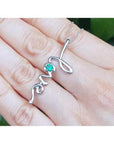 14K white gold "love" script pendant necklace with a round Colombian emerald.