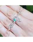 14K white gold "love" script pendant necklace with a round Colombian emerald.