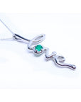A white gold necklace with a script love pendant featuring an emerald stone on a white background.