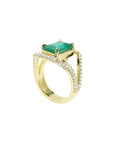 Gold ring with a emerald May birthstone for women and diamond accents on a white background.