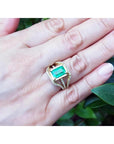 Emerald engagement ring, 2.86 ct. green emerald in 18K yellow gold with three rows of diamonds.