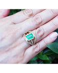 Emerald engagement ring, 2.86 ct. green emerald in 18K yellow gold with three rows of diamonds.