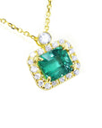 Emerald necklace east west orientation encircled in a halo of natural diamonds, crafted in 14k yellow gold