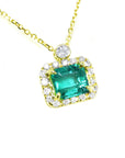 Emerald jewelry necklace east west orientation encircled in a halo of natural diamonds, crafted in 14k yellow gold
