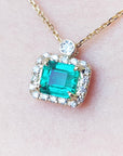 Real emerald necklace for sale east west orientation encircled in a halo of natural diamonds, crafted in 14k yellow gold