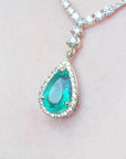 magnification of women's emerald necklace high quality pear cut in 18k yellow gold, encircled by a halo diamond