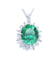 Oval cut medium light green emerald pendant with diamond halo in 14K white gold.