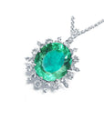 Emerald pendant with halo diamond accents on a white gold chain topside visible