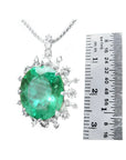 10.91 ct. oval emerald pendant with diamond halo in 14K white gold, shown next to a ruler.
