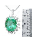 10.91 ct. oval emerald pendant with diamond halo in 14K white gold, shown next to a ruler.
