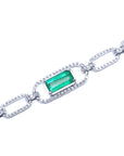 The topside view of a paperclip style bracelet with a natural colombian emerald on a white background
