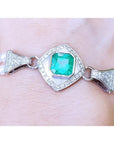 Emerald-cut Colombian emerald and pearls bracelet crafted in 18k white gold on a wrist.