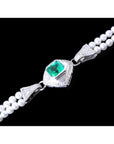 18K white gold emerald and pearl bracelet with a medium green emerald, diamonds, and two strands of pearls.