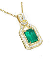 A 18k yellow gold emerald pendant with natural accent diamonds surrounding the square gemstone.