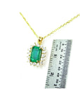 14K yellow gold emerald pendant with natural halo diamonds, shown next to a ruler for scale.