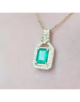 2.06 ct. emerald pendant with natural diamonds in 18K yellow gold, worn on a woman's neck.