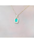 2.06 ct. emerald and natural diamond pendant in 18K yellow gold, worn on a woman's neck.