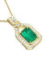A 18k yellow gold emerald pendant with natural accent diamonds surrounding the square gemstone, toside view.