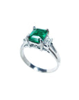 On a left side profile, a natural emerald three stone ring for women.