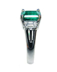 Platinum emerald ring on a side profile.