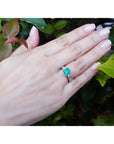 1.62 ct. square emerald ring with princess cut diamonds on a 14K white gold band, worn on a hand.