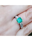 1.62 ct. square emerald ring with princess cut diamonds on a 14K white gold band.