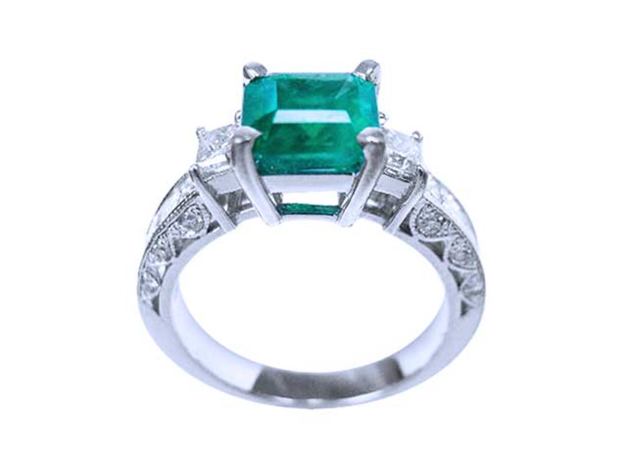 This colombian emerald ring displays its lateral position, where top setting, gallery and decorated band profile are visibles/