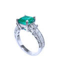 A vibrant emerald on top and side princess cut diamonds on the band of this ring are beautifully displayed.