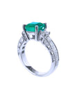 An emerald-cut real Colombian emerald ring on a half side positon, top and band profile visibles.