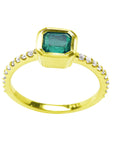 14k yellow gold emerald ring and diamond-studded band on a white background.