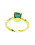 Bezel-set emerald ring with accent diamonds on a 14K yellow gold band.